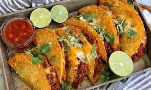 Crispy Oven Baked Tacos Crispy oven baked tacos with ground beef and melted cheese arranged on a baking sheet, golden and crunchy fresh from the oven