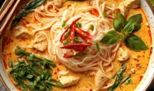 Damn Delicious Thai Red Curry Noodle Soup Damn Delicious Thai Red Curry Noodle Soup in a white bowl with fresh cilantro, basil, and a lime wedge garnish