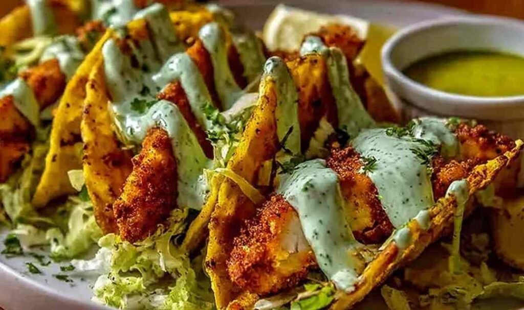 Dill pickle ranch smash chicken tacos on a wooden board topped with cheese lace, shredded cabbage, and cottage cheese ranch sauce