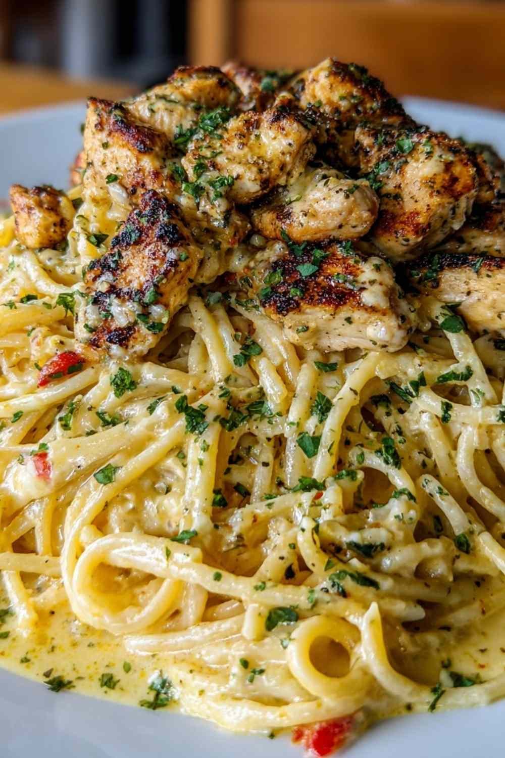 Creamy Cajun chicken spaghetti in a large skillet with golden broiled mozzarella and bold red Cajun sauce