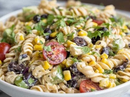 Large bowl of southwest pasta salad with rotini, grilled chicken, black beans, corn, tomatoes, and cilantro coated in chipotle ranch dressing