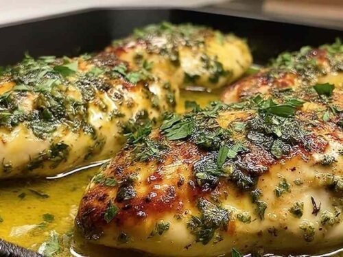 Juicy garlic butter baked chicken breast with golden top and fresh parsley in a baking dish