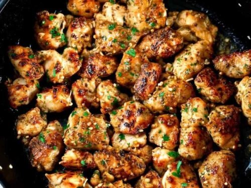 Garlic butter chicken bites in a skillet with fresh parsley and golden garlic butter sauce