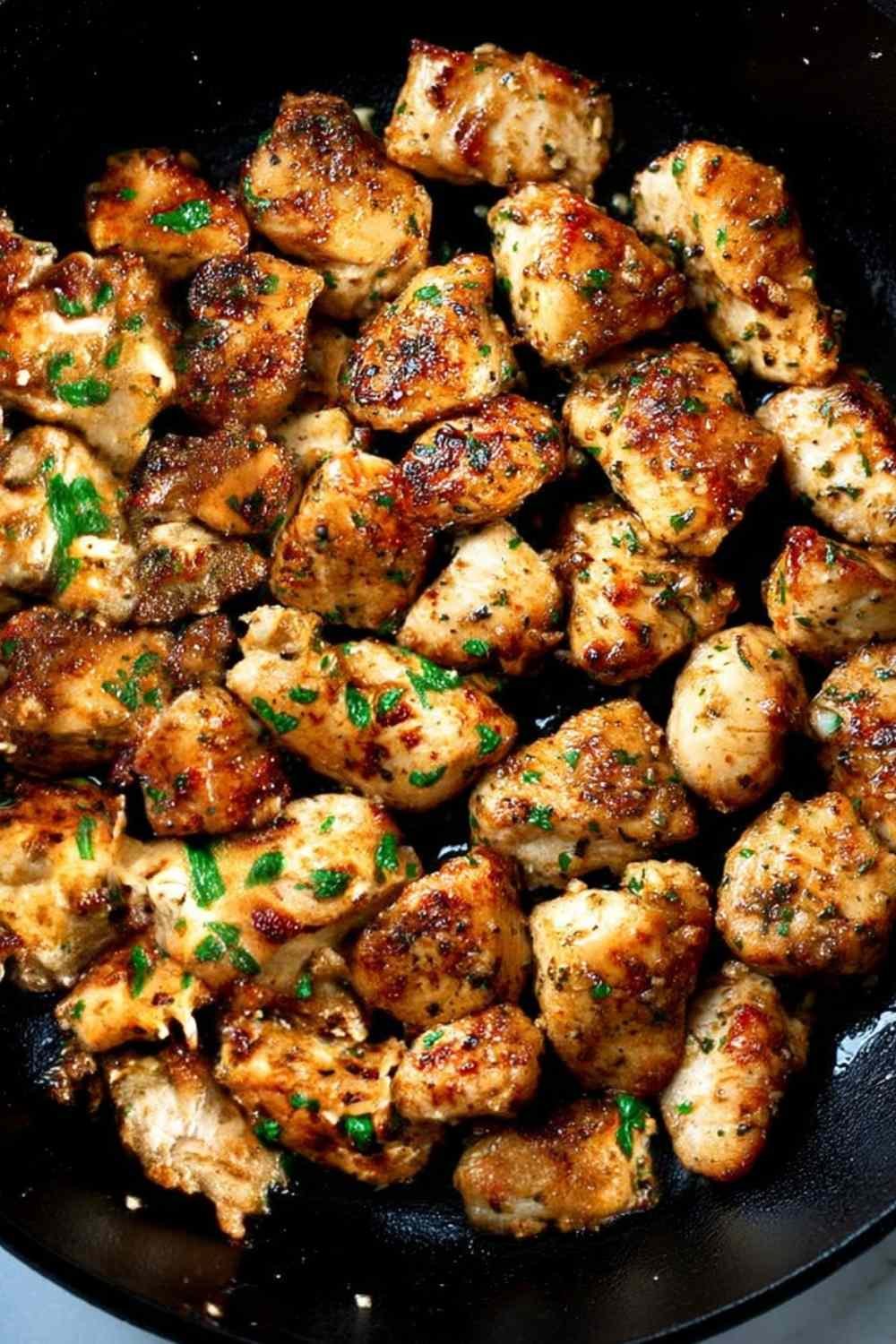 Garlic butter chicken bites in a skillet with fresh parsley and golden garlic butter sauce