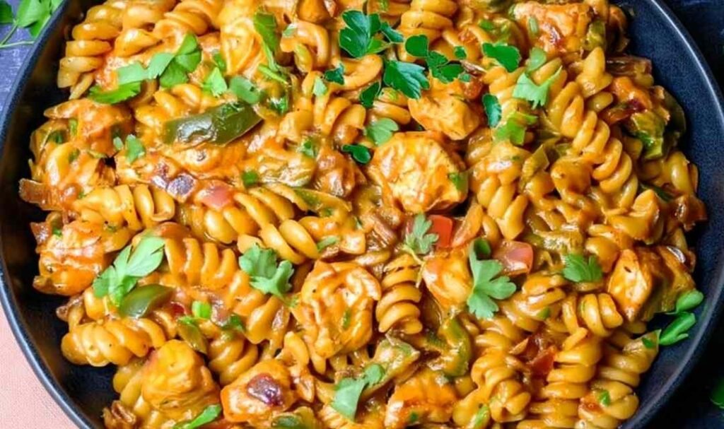 High protein chicken fajita pasta in a large skillet with creamy cheese sauce, smoky chicken, bell peppers, and fresh parsley