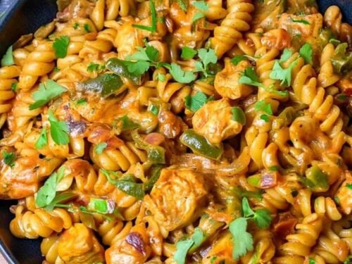 High protein chicken fajita pasta in a large skillet with creamy cheese sauce, smoky chicken, bell peppers, and fresh parsley
