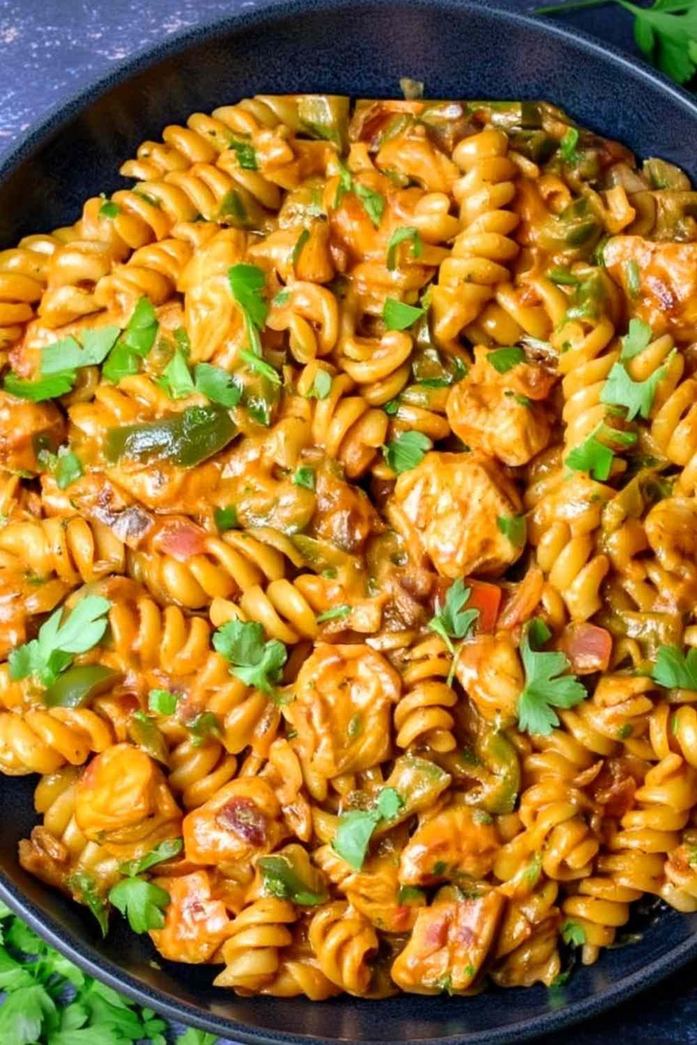 High protein chicken fajita pasta in a large skillet with creamy cheese sauce, smoky chicken, bell peppers, and fresh parsley