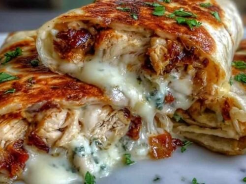 Low carb cheesy garlic chicken wraps sliced diagonally on a plate showing melted mozzarella and cheddar filling with fresh parsley garnish