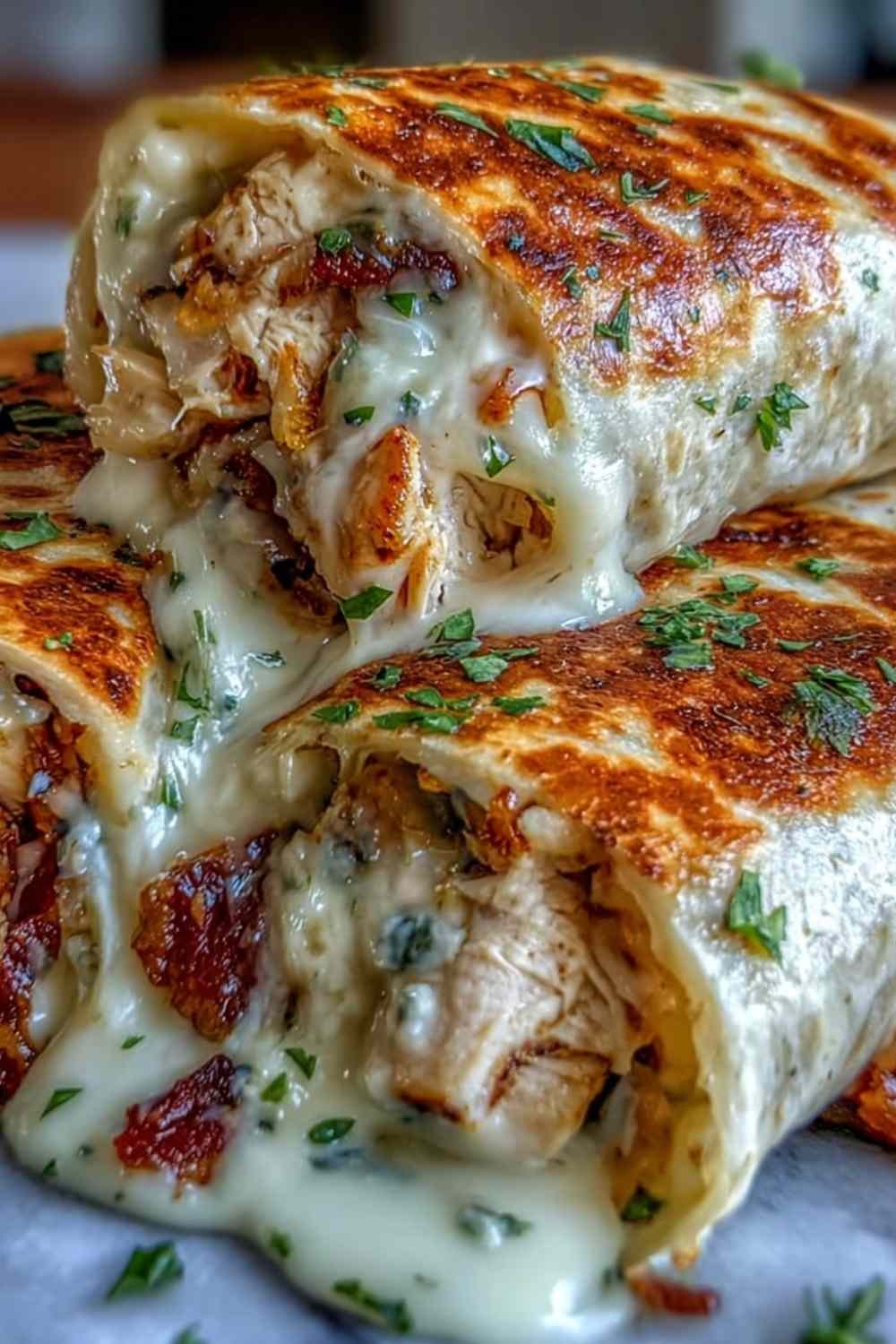 Low carb cheesy garlic chicken wraps sliced diagonally on a plate showing melted mozzarella and cheddar filling with fresh parsley garnish