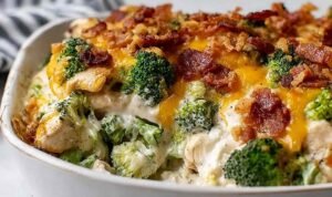 Creamy low carb chicken casserole with broccoli and bacon in a 9x13 baking dish with golden melted cheddar and mozzarella on top