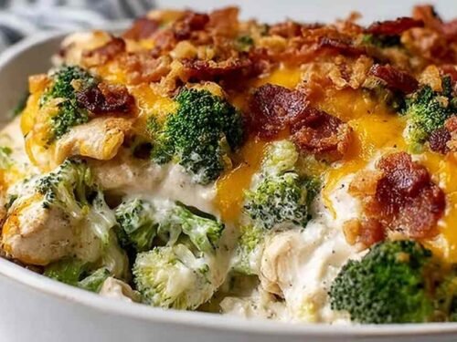 Creamy low carb chicken casserole with broccoli and bacon in a 9x13 baking dish with golden melted cheddar and mozzarella on top