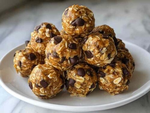 No-Bake Peanut Butter Energy Bites arranged on a white plate with mini chocolate chips scattered around