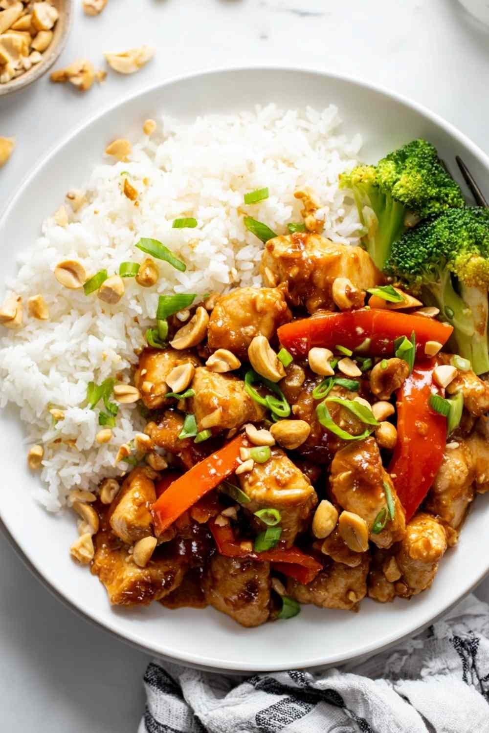 Bowl of peanut butter chicken with stir-fried vegetables served over white rice