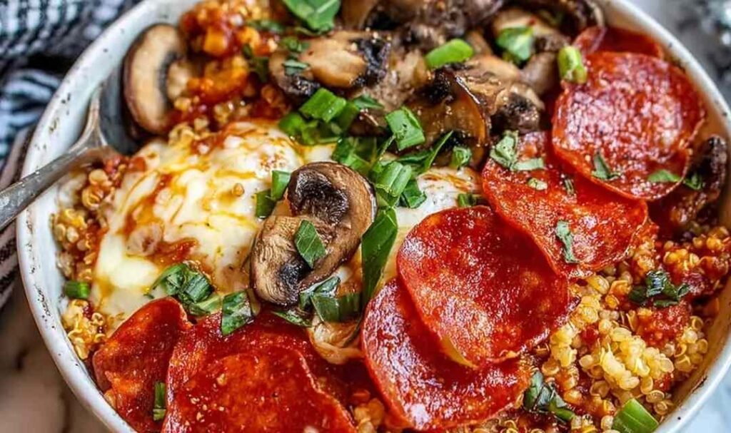 Pizza protein bowl with bubbling melted mozzarella and pepperoni on a quinoa mushroom base in a white bowl