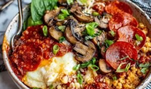 Pizza protein bowl with bubbling melted mozzarella and pepperoni on a quinoa mushroom base in a white bowl