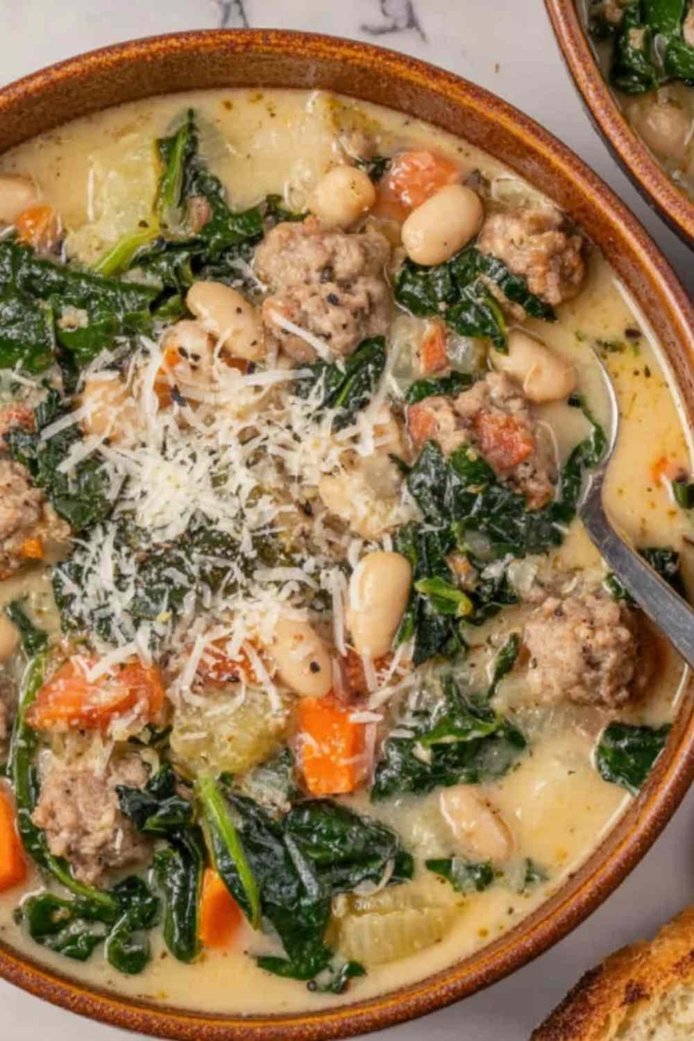Italian Sausage and White Bean Soup in a Dutch oven topped with fresh parsley and grated Parmesan cheese