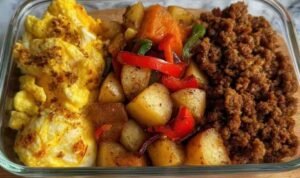 Tex-Mex protein breakfast bowls with taco chicken, roasted potatoes, peppers, and scrambled eggs in glass meal prep containers